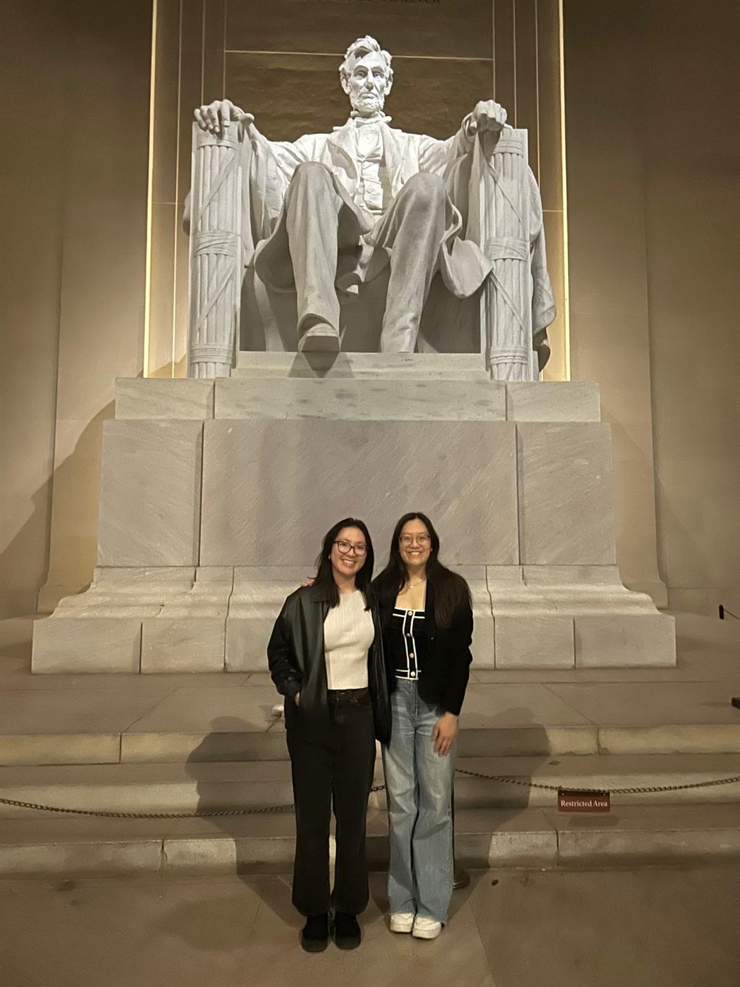 Two Harvard Moot Court members at the Lincoln Memorial in Washington, D.C. at night.