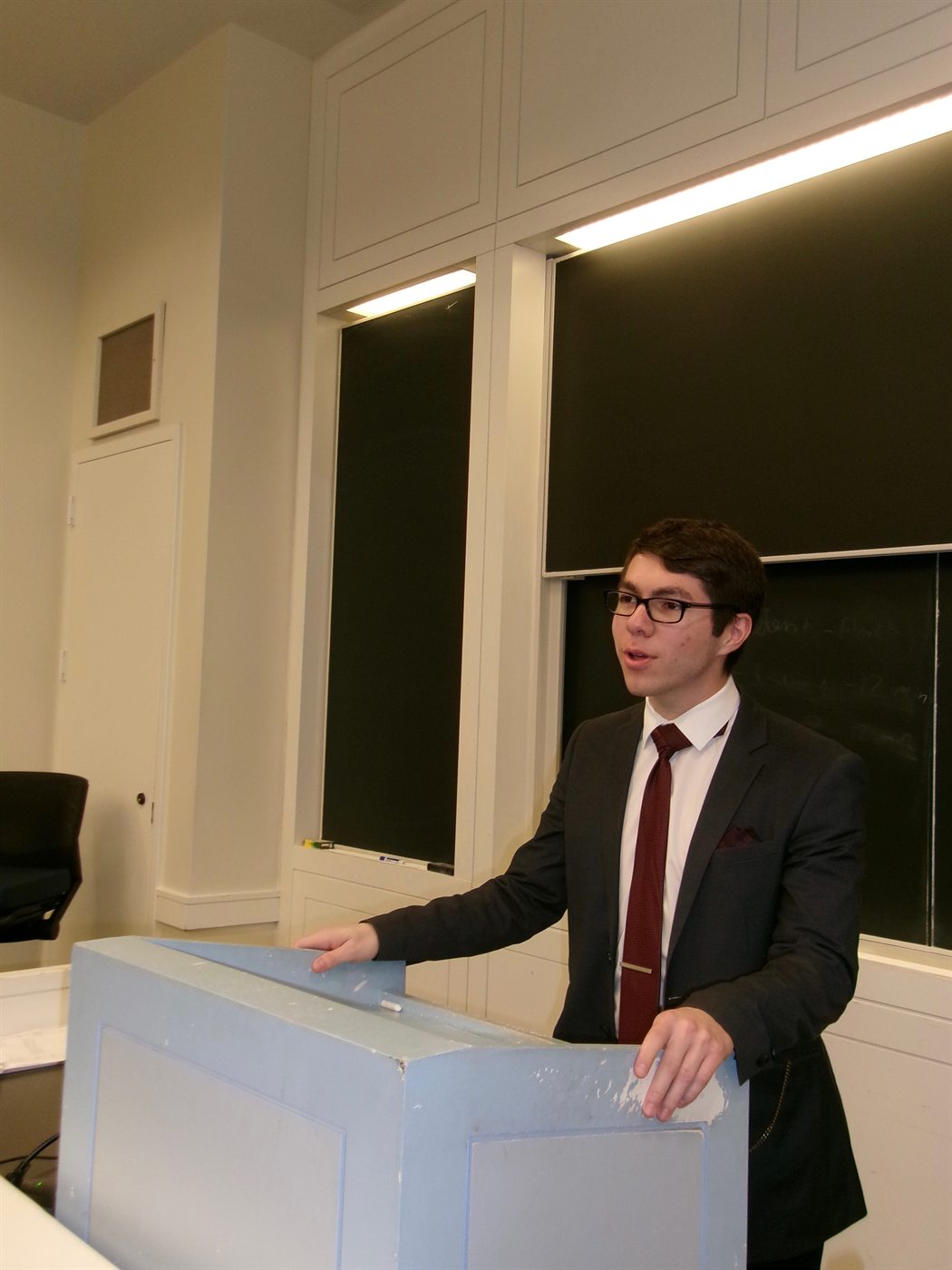 A Harvard Undergraduate Moot Court member delivering an oral argument from a podium.